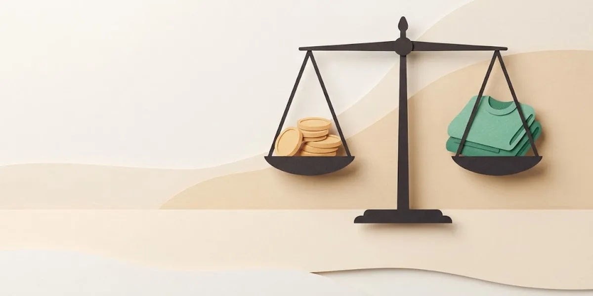 Paper-cut illustration of a balance scale weighing coins against a sweater